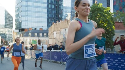 Slow Motion of a Diverse Group of People Running a Marathon in a City During the Day. Active and Fit Smiling Female Runner Competing to Reach the Finish Line, Supported by Friends and Family
