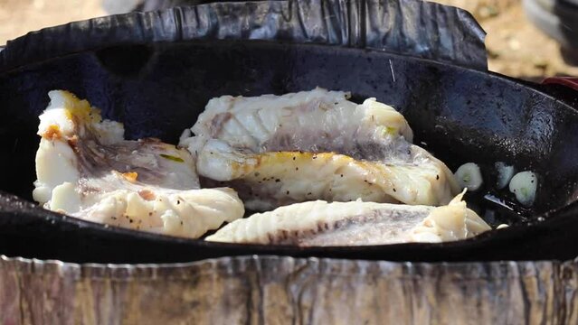 Flipping fish fillets on a pan