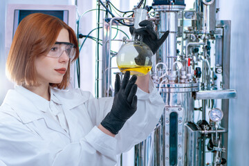 Woman biologist. Girl scientist with flask. Laboratory assistant near bioreactor. Woman biologist...