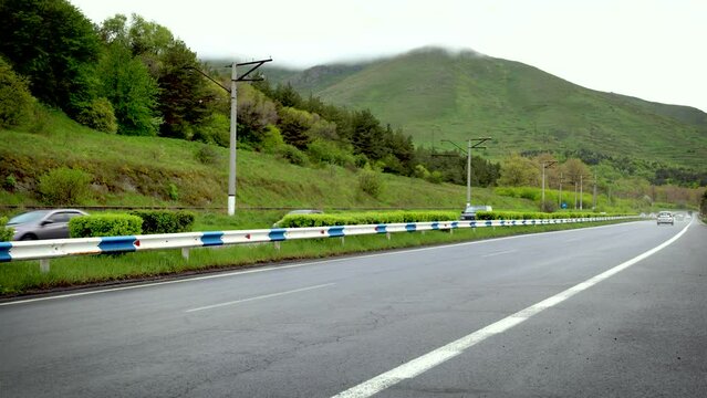 Time lapse of cars driving along the Yerevan Sevan highway against the backdrop of a mountain partially obscured by low clouds, UHD, 4K