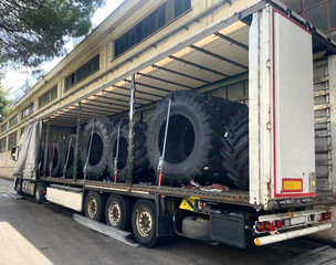 Cargo transportation of tractor wheels in a semi-trailer truck. Side loading of wheels