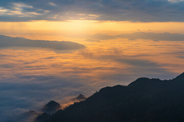 sunrise behind the mountains with sea of cloud and beautiful sky in the northern of Thailand (Phu Chi Dao Chiang Rai Province)