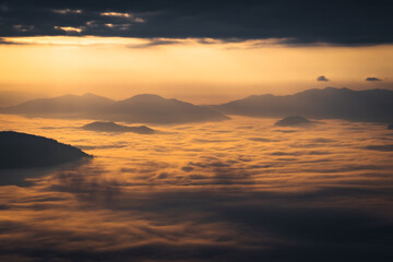 sunrise behind the mountains with sea of cloud and beautiful sky in the northern of Thailand (Phu Chi Dao Chiang Rai Province)