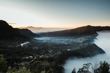 Cemoro Lawang village near Gunung Bromo or Mount Bromo is covered by clouds at dawn viewed from Seruni Sunrise Point