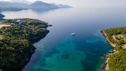 Fototapeta na wymiar Aerial drone ultra wide panoramic photo of luxury sailboat anchored in tropical exotic island with crystal clear turquoise sea and pine trees