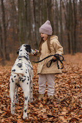 little girl with dog in autumn forest