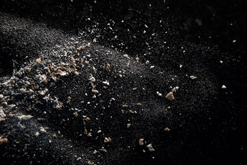 Abstract image made with flour and breadcrumbs on dark background. Conceptual image, alluding to space and cosmos, the unknown, light and darkness.