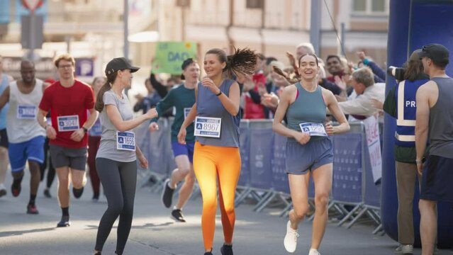 Women Supporting Women: Portrait of Happy Female Runners Participating in a Marathon. Group of Friends Celebrating Together and Congratulating Each Other on Crossing the Finish Line