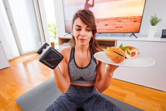 Woman choosing between workout or unhealthy fast food
