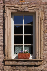 Baroque window with flower pot and vintage curtain on a residential house in the old village of...