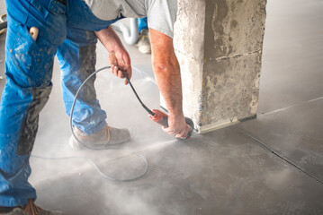 Crop worker cutting concrete with angle grinder