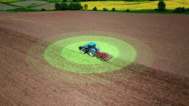 Aerial view of a self-driving autonomous agricultural tractor cultivating a field. Scanning the environment, sensors and GPS system position the vehicle. Smart agriculture, driverless transportation. 