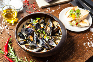 Blue mussels in cream wine sauce. Delicious healthy Italian traditional food closeup served for lunch in modern gourmet cuisine restaurant