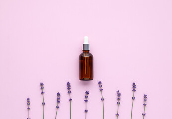 Essential oil of lavender in glass bottle with a pipette. A flacon of fragrant oil and purple...