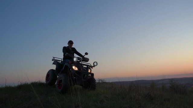 ATV riding slowly at sunset,active recreation in nature on a quad bike