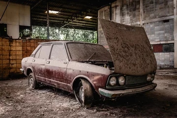 Foto op Plexiglas Schipbreuk Old car with dust and dirt stuck in an abandoned building. vintage car