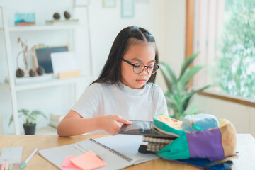 Pupil child put books and notes into backpack. School supplies.Back to school concept. Kid prepare for studies. Portrait cute little girl packing backpack .