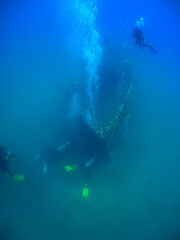 Naklejka na ściany i meble some divers exploring a small sunken ship in the caribbean sea