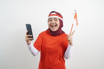 Fototapeta na wymiar Happy Indonesian Woman holding flag with smartphone