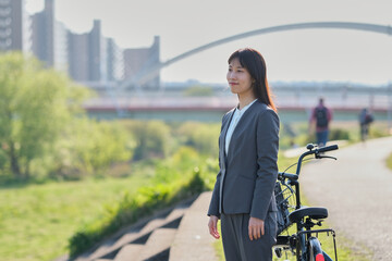 自転車を降りて景色を眺めるビジネスウーマン