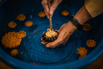 The process of casting a candle cup with wild fruit seeds to worship the Buddha on Buddhist Lent Day in Ubon Ratchathani Province, Thailand