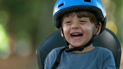 Happy little boy wearing bicycle helmet laughing and smiling