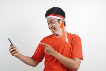 Man celebrating independence day carry flag and point at a phone.