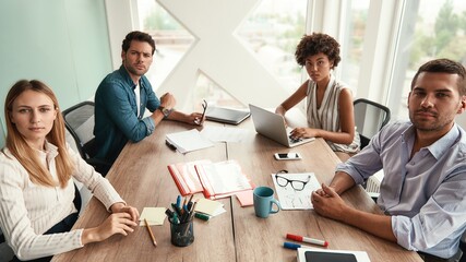 Fototapeta premium Successful team. Group of young business people looking at camera while working together in the modern office