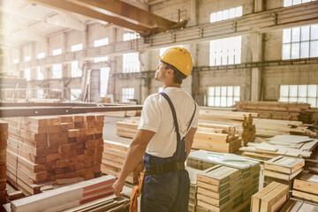 Male worker standing by construction materials in building