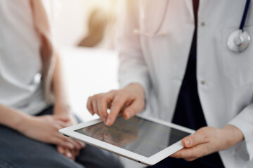 Doctor and child patient. The doctor is using tablet computer and is ready to examine the boy. The concept of ideal health in medicine