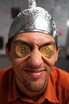 Stupid conspiracy theorist with bitcoin coins in his eyes.Secrets and fake news. Conspiracy theory. Cryptocurrency. Myths and Reality