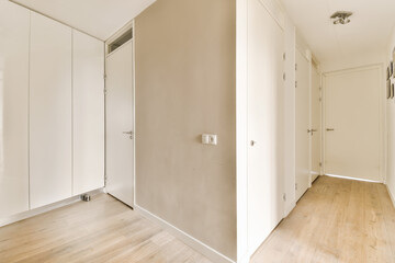 an empty room with wood floors and white walls, two doors open to reveal another room in the same space