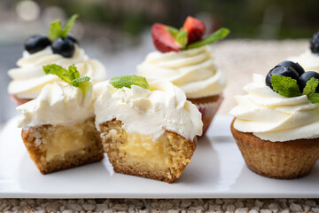 Cupcakes with different fruits on a white plate close-up.