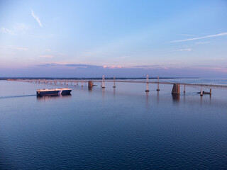 An aerial photo of a Cargo Boat passing under the Chesapeake Bay Bridge in Annapolis Maryland...
