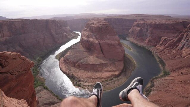 jambes dans le vide face au colorado a Horseshoe Bend en Arizona