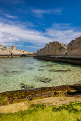Fototapeta premium The amazing natural pools of Marina Serra, in Puglia, Salento, Tricase. The clear and crystalline turquoise sea, between the rocky cliff. The blue sky, in the summer. The ancient watchtower.