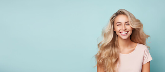 Smiling young woman with blonde long groomed hair isolated on pastel flat background with copy space. Blonde hair care products banner template, hair salon. - obrazy, fototapety, plakaty
