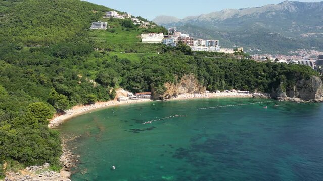 Beautiful top view of Mogren beach, clear sea and bathing people. Budva. Montenegro. Aerial view.