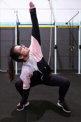 Fototapeta na wymiar Active Young Woman Stretching at the Gym before a fitness class