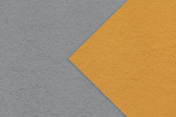 Texture of dark gray paper background, half two colors with orange arrow, macro. Structure of craft...
