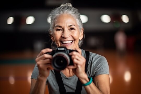 Portrait of happy senior woman taking picture with camera in bowling club