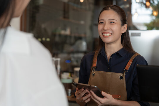 Asia Woman Owner Happy And Smile Receive Order From Customer. Guarantees Safety, Cleanliness, Open The Coffee Shop. Open For New Normal. Small Business, Welcome, Restaurant, Home Made, Cafe