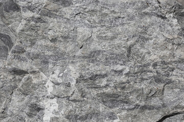 The texture and pattern of the dark gray granite exposed in the sunlight clearly show the dimensionality of the surface.