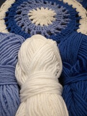Blue, white round crochet elements and balls of yarn. Crochet texture, place for an inscription, adapted for mobile phone