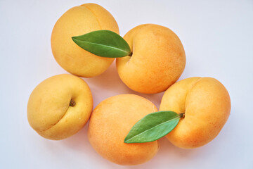 Apricots with leaves on a white background. View from above. Close-up