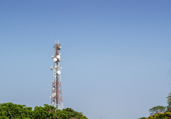 Telecommunications towers and telecommunication networks, satellite dishes against blue sky.
