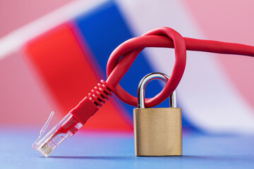 Closed padlock on a knotted network wire against the background of the Russian flag, a concept on...