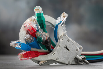 Network wires sticking out of closed handcuffs, a concept on the theme of an arrest for hacking network telecommunications and hacker attacks