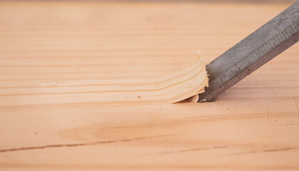 carpenter chipping wood with chisels
