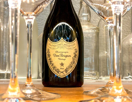 Orlando, Florida, USA - 19 June 2023: Bottle of Dom Perignon vintage champagne viewed between defocussed flute glasses on a table in a fine dining restaurant in Orlando.